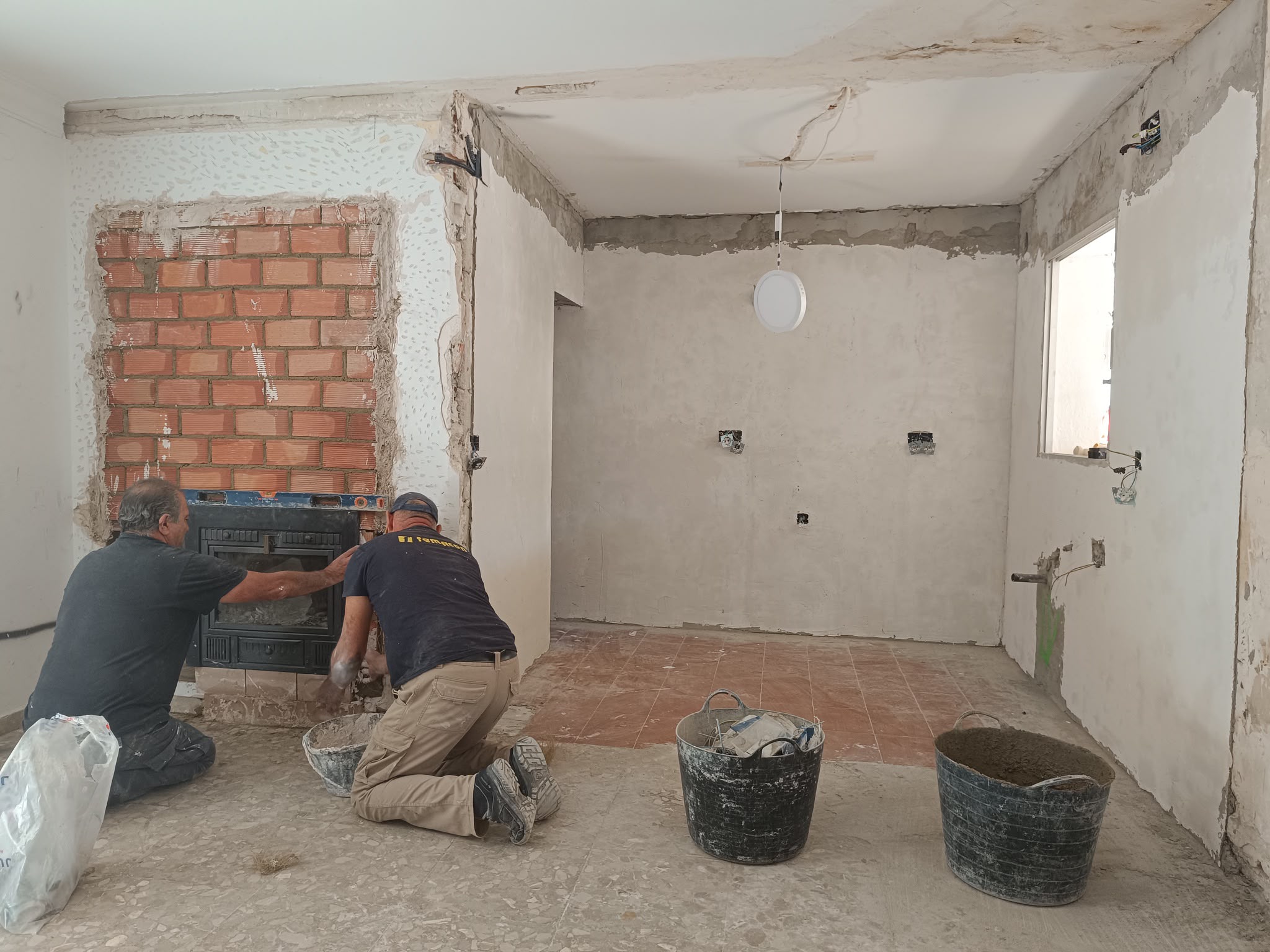 Equipo instalando la chimenea en la zona del salón