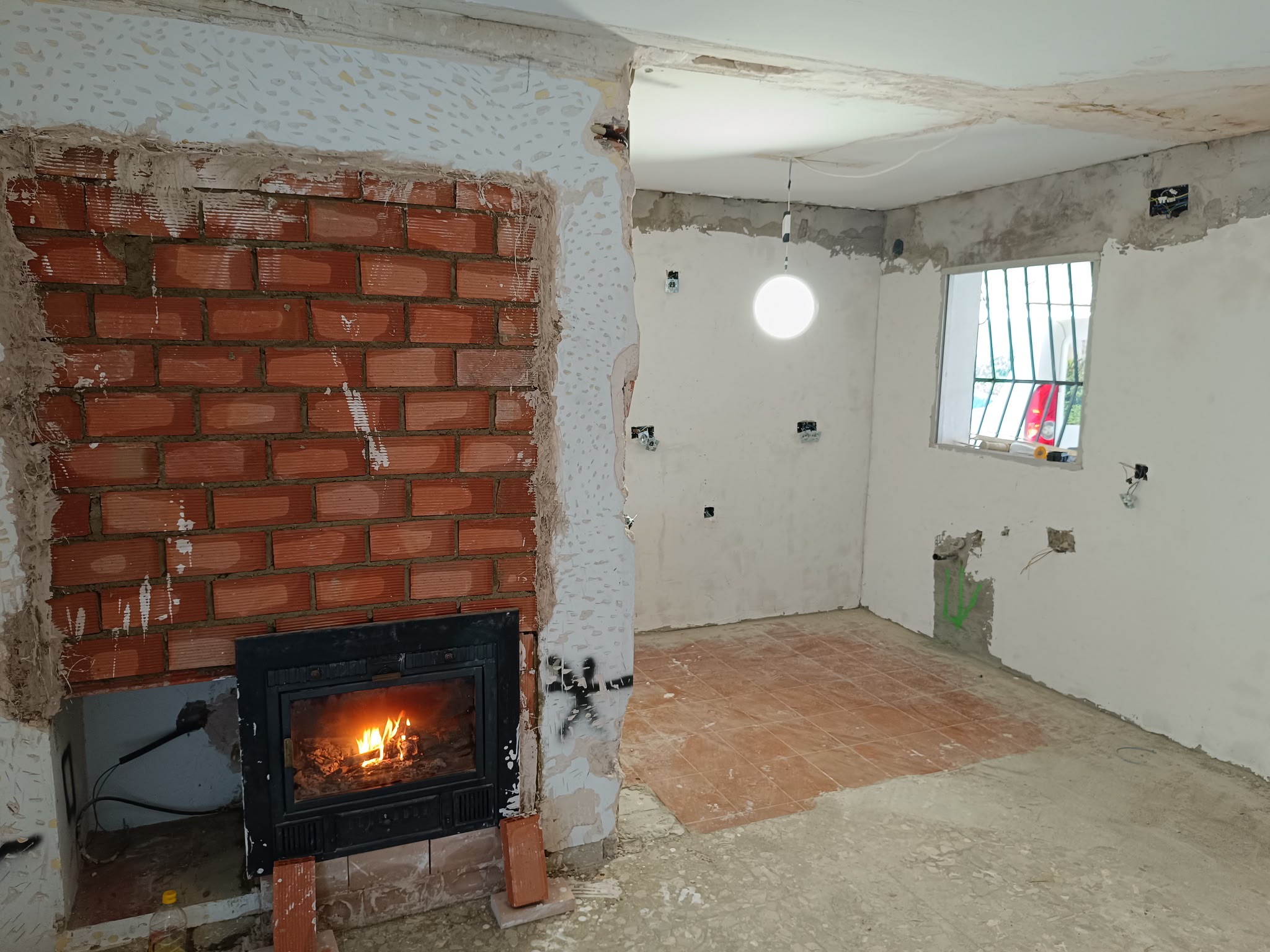 Nueva chimenea encendida con el revestimiento todavía en obra