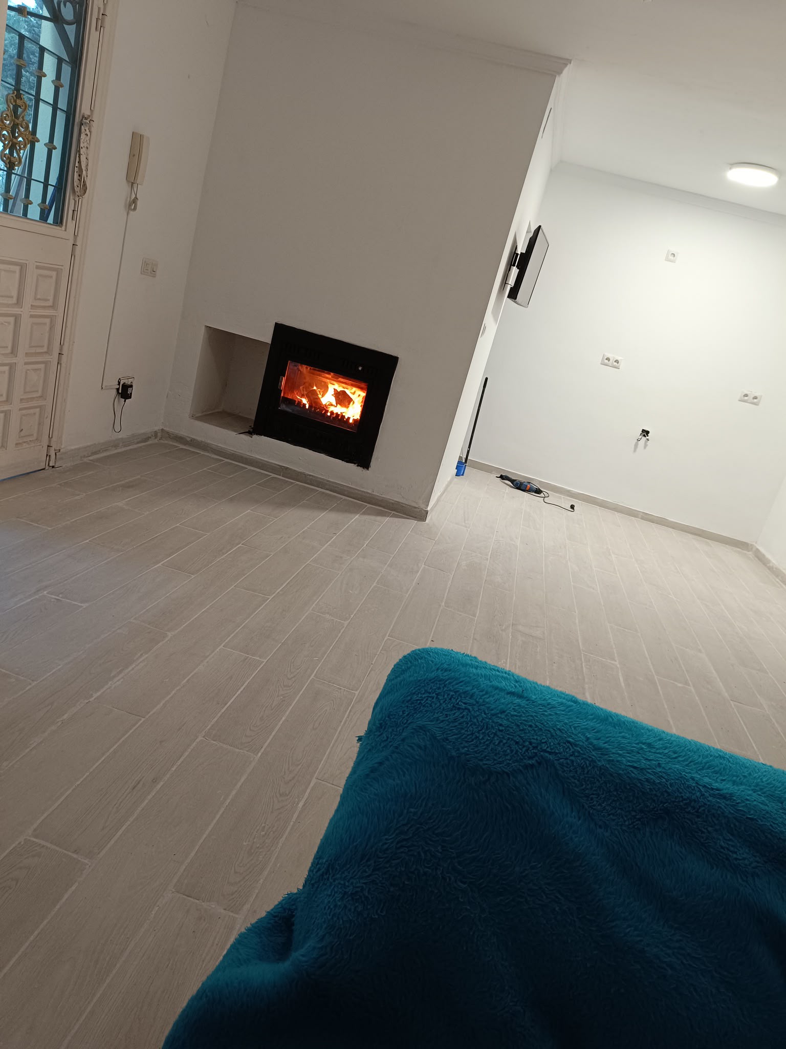 Salón renovado con la nueva chimenea encendida y nueva solería