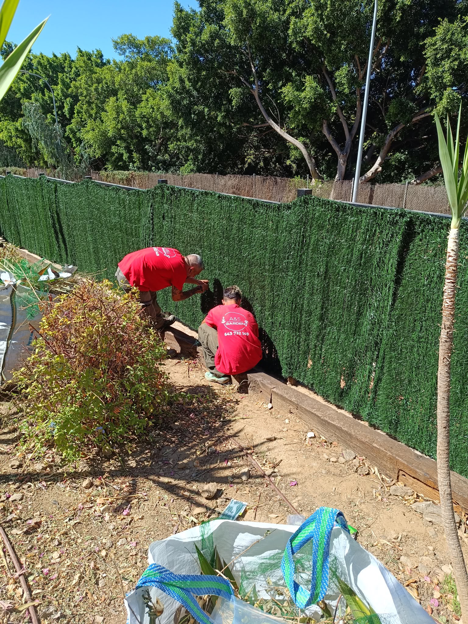 Equipo trabajando en el cerramiento del mismo jardín comunitario