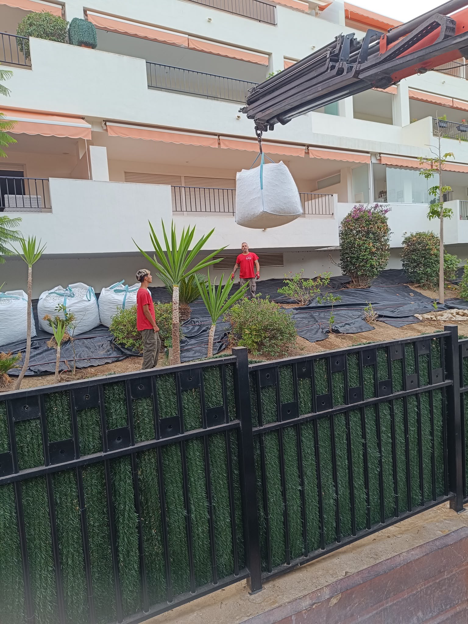 Aporte de materiales con grúa en el proyecto del jardín con grava blanca