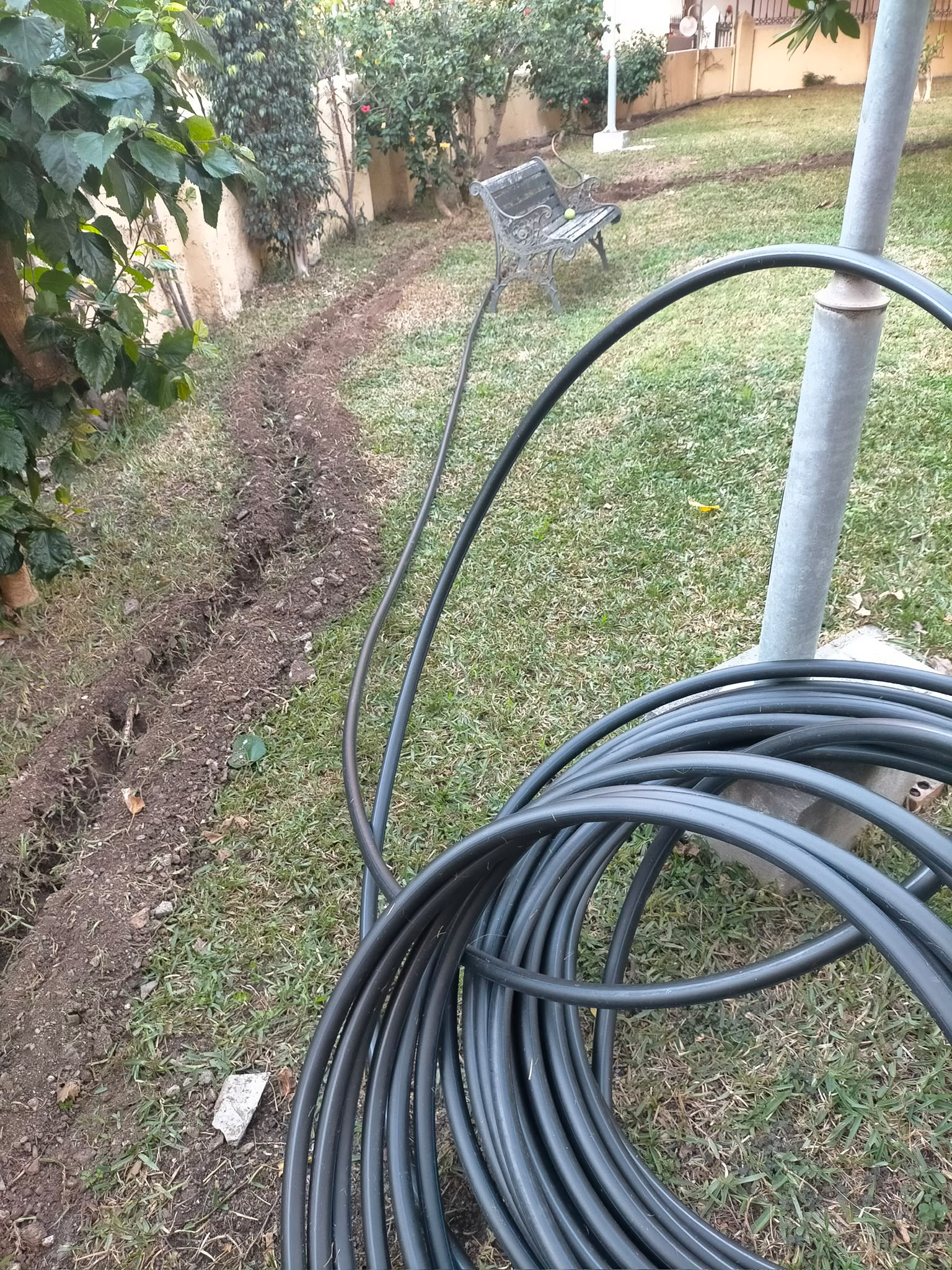 Tubería preparada para instalar en una zanja junto al jardín